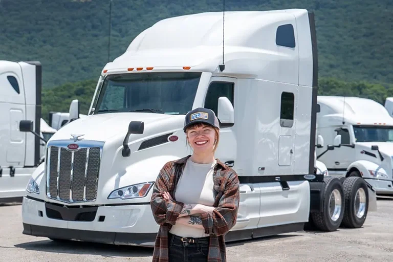 Solo owner operator proudly standing in front of truck