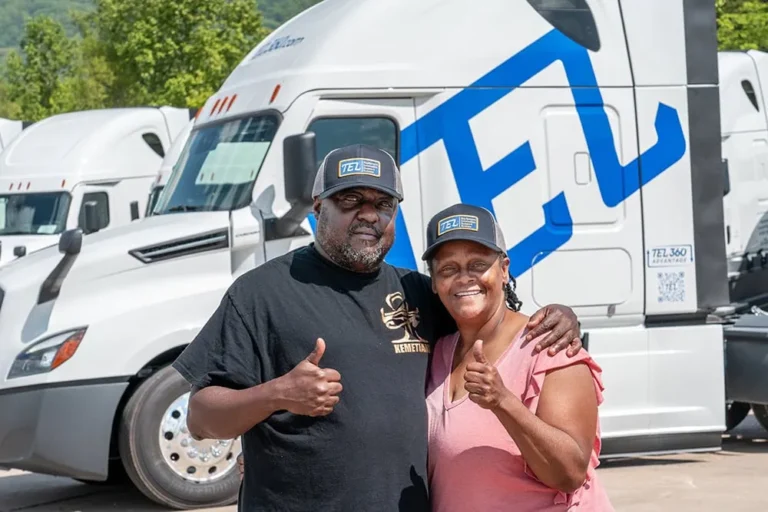 Owner Operator Team proudly standing in front of TEL truck